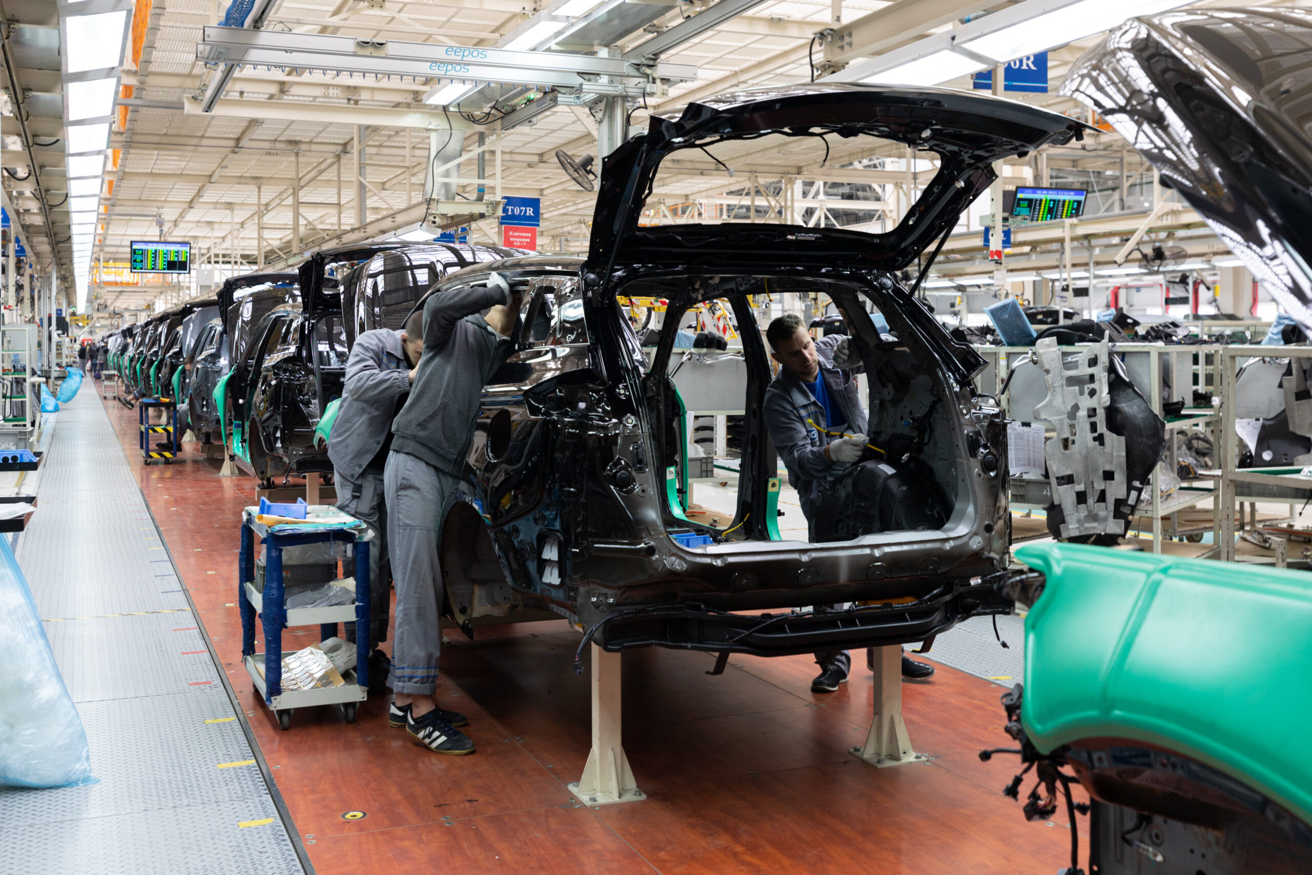 Car bodies are on assembly line. Factory for production of cars. Modern automotive industry. A car being checked before being painted in a high-tech enterprise